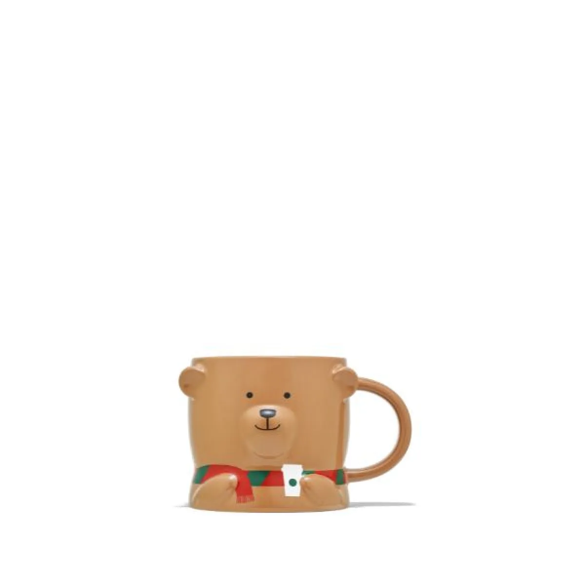 Brązowy ceramiczny kubek w formie misia z uśmiechniętą buzią. Misiu ma czerwono-zielony szalik z małą zawieszką w kształcie kubka Starbucks. Uchwyt kubka znajduje się po prawej stronie.