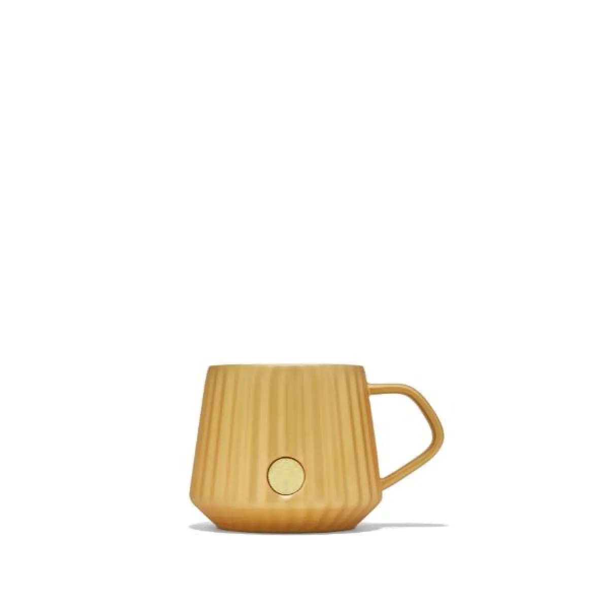 Kubek w odcieniu matowego złota z pionowymi żłobieniami na powierzchni. Ma prosty uchwyt i okrągły złoty detal na przodzie.