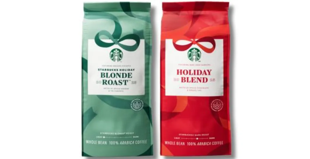 Dwa opakowania kawy ziarnistej Starbucks w świątecznym designie. Po lewej stronie zielone opakowanie z napisem „Starbucks Holiday Blonde Roast” – zawiera nuty pomarańczy i figi, jest oznaczone jako jasne palenie (Blonde Roast) i 100% Arabica. Po prawej stronie czerwone opakowanie z napisem „Holiday Blend” – zawiera nuty przypraw, czekolady i gałązek świerku, jest oznaczone jako ciemne palenie (Dark Roast) i 100% Arabica. Oba opakowania mają ozdobne grafiki w formie wstążek, nawiązujące do świątecznej tematy